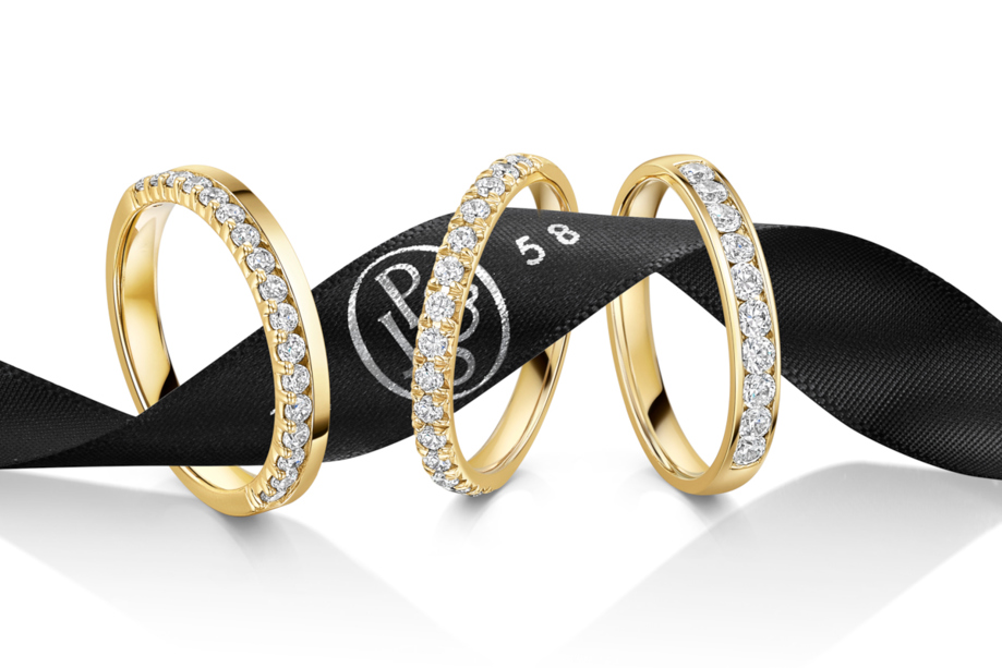 Three gold diamond wedding bands on a ribbon with James Porter & Son logo